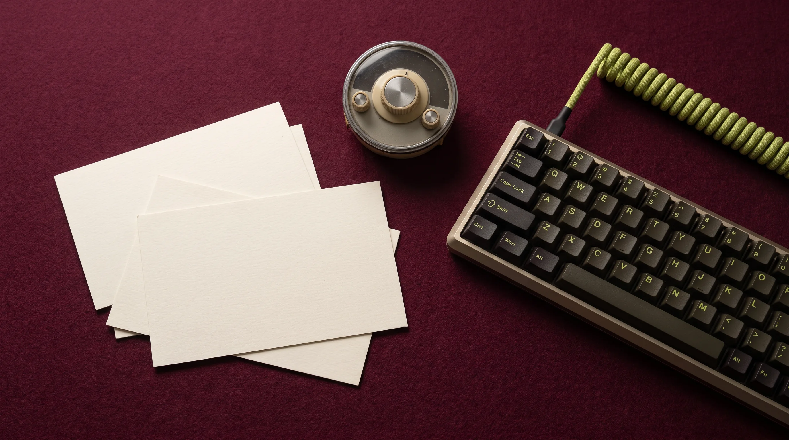 Keyboard, cable and paper cards arranged on burgundy cloth